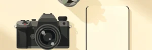 Professionele camera op een minimalistisch bureau naast een open notitieboek en klein kamerplantje, gefotografeerd van bovenaf.
